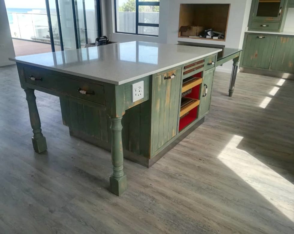 kitchen island in dark green with sleek white countertop surface