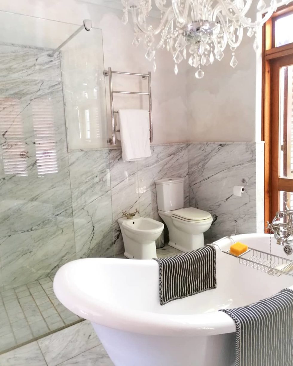 white bathtub paired with bathroom wall cladding