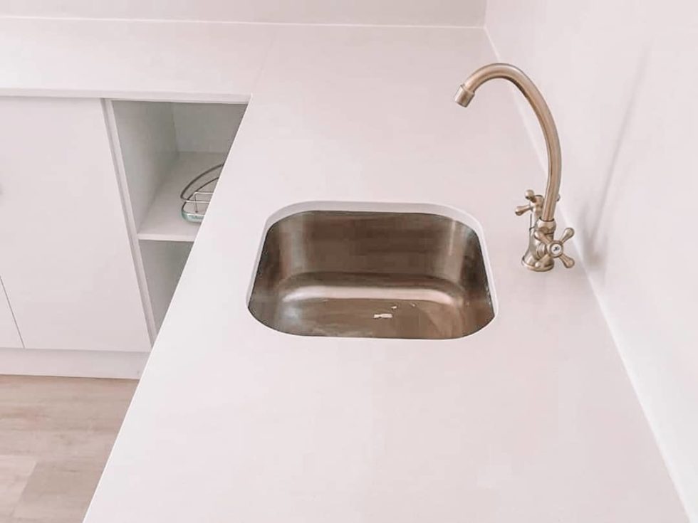 undermount kitchen sink surrounded by white countertop