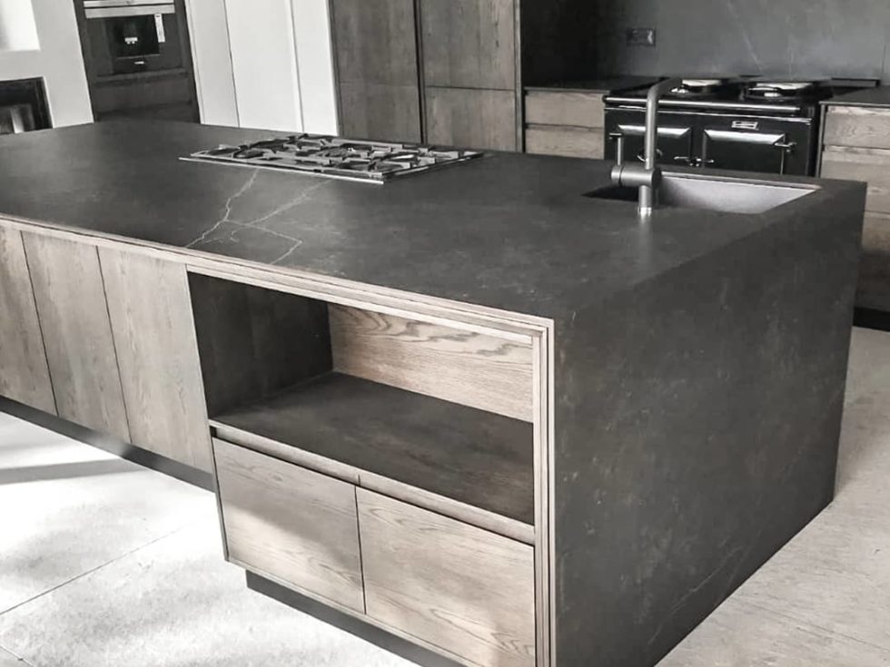 modern kitchen with dark grey waterfall counter and dark cabinetry